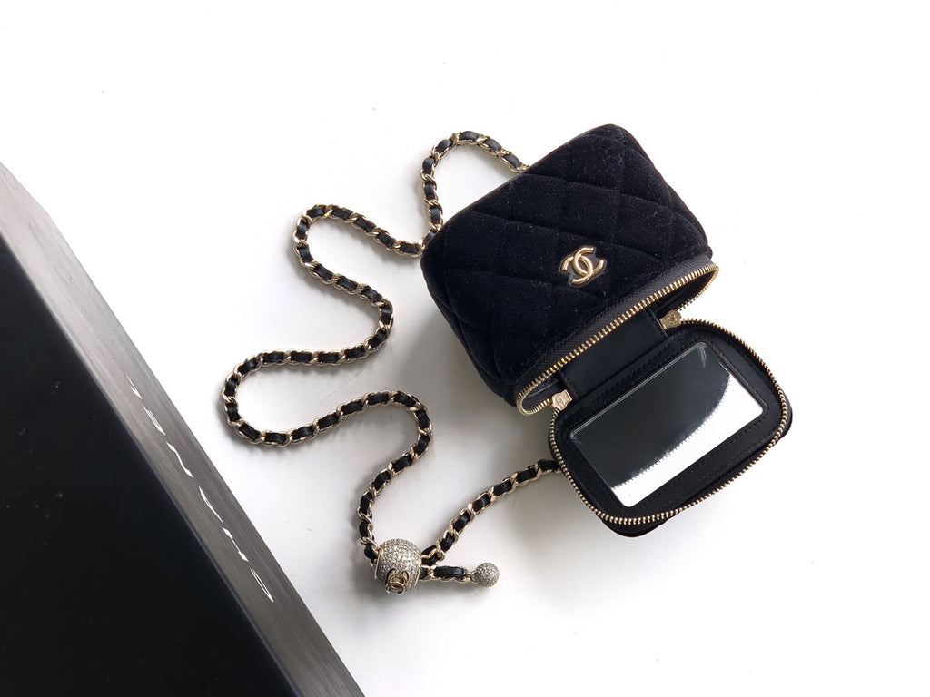 Dark navy Chanel mini bag with gold zipper, chain strap, and top handle