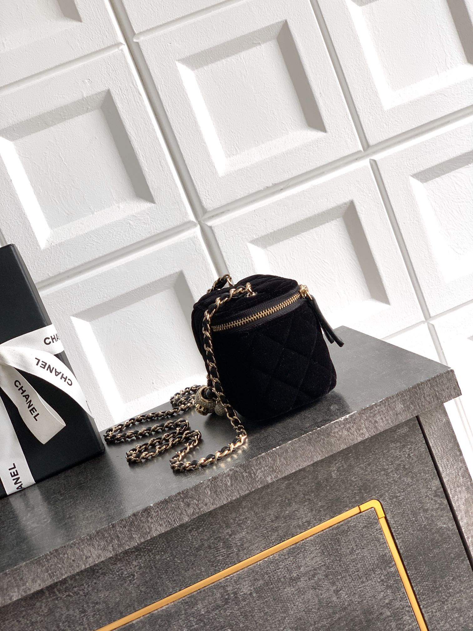 Black Chanel quilted mini bag with chain strap and gold zipper pull