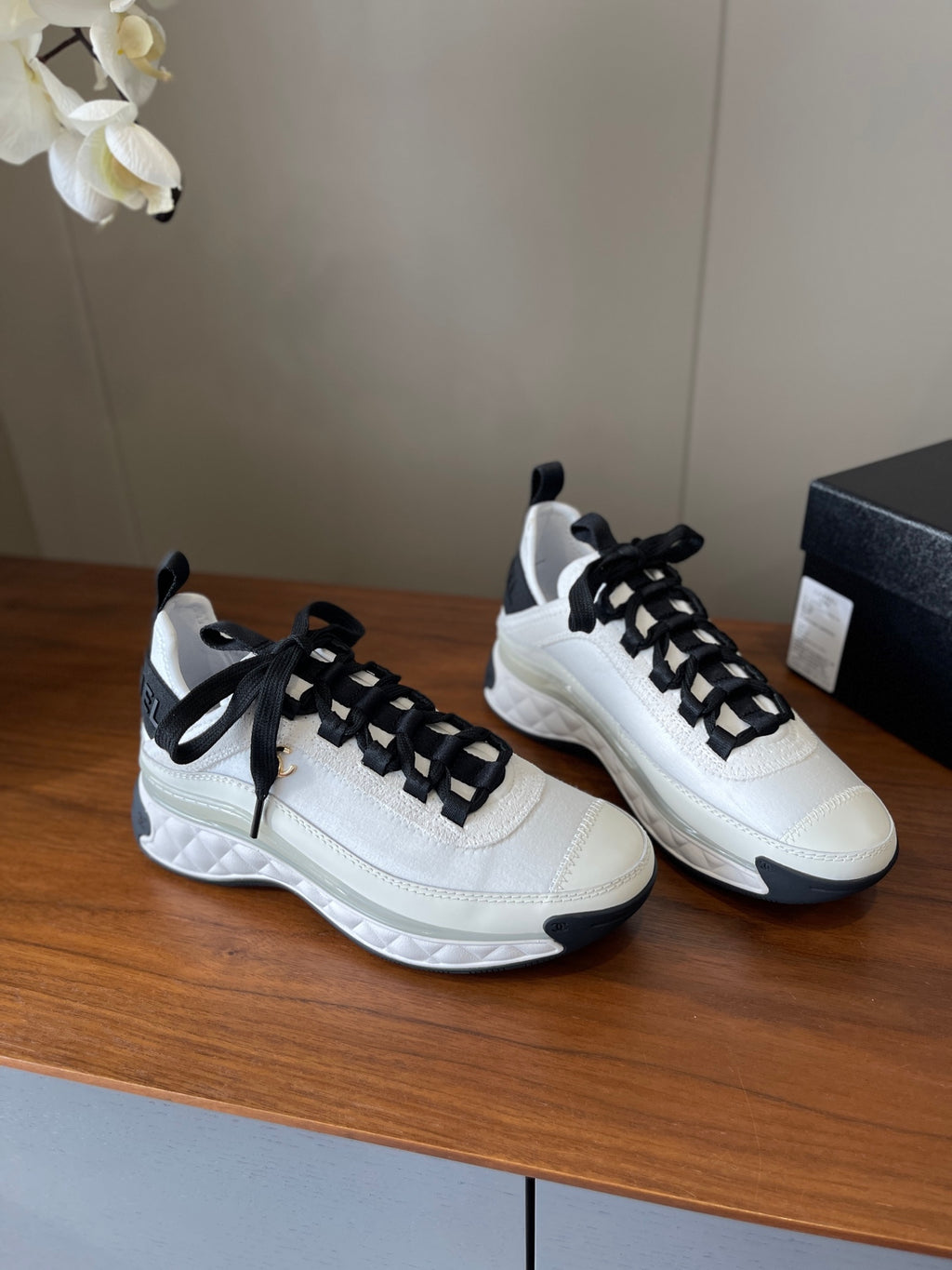 White high-top sneakers with black laces, padded collar, chunky sole
