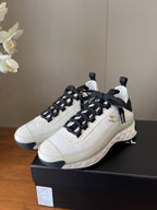 White leather sneakers with black laces and Chanel CC logo, cushioned sole