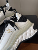 White sneaker with quilted side panel, black laces, gold Chanel CC logo