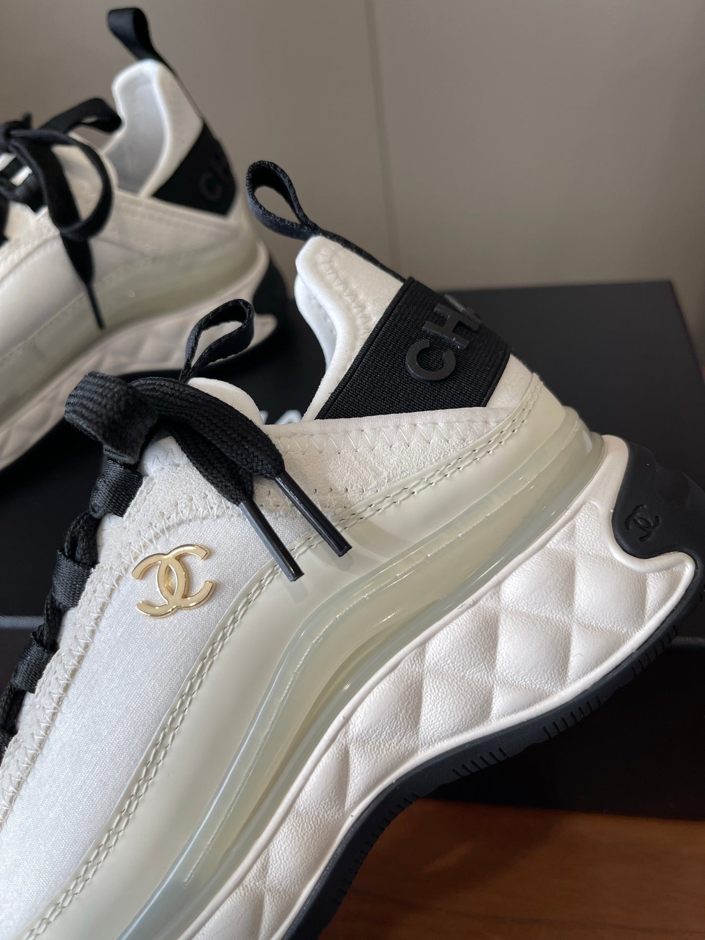 White sneaker with quilted side panel, black laces, gold Chanel CC logo