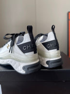 White and black sneakers with CHANEL heel branding on stacked sole