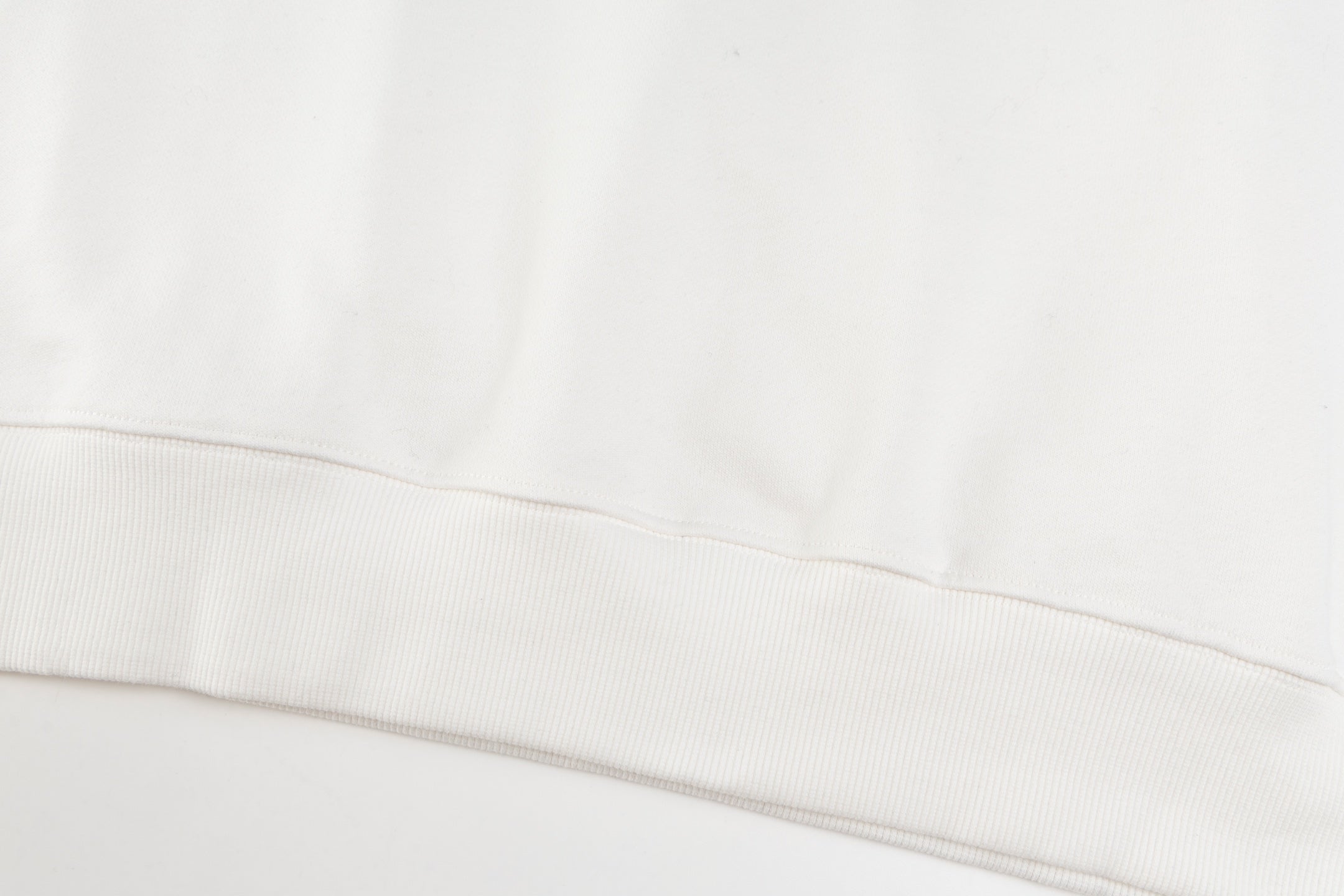 White crewneck sweatshirt hem with ribbed waistband