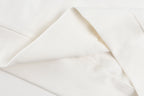 White long-sleeve garment fabric, seam and folded cuff close-up