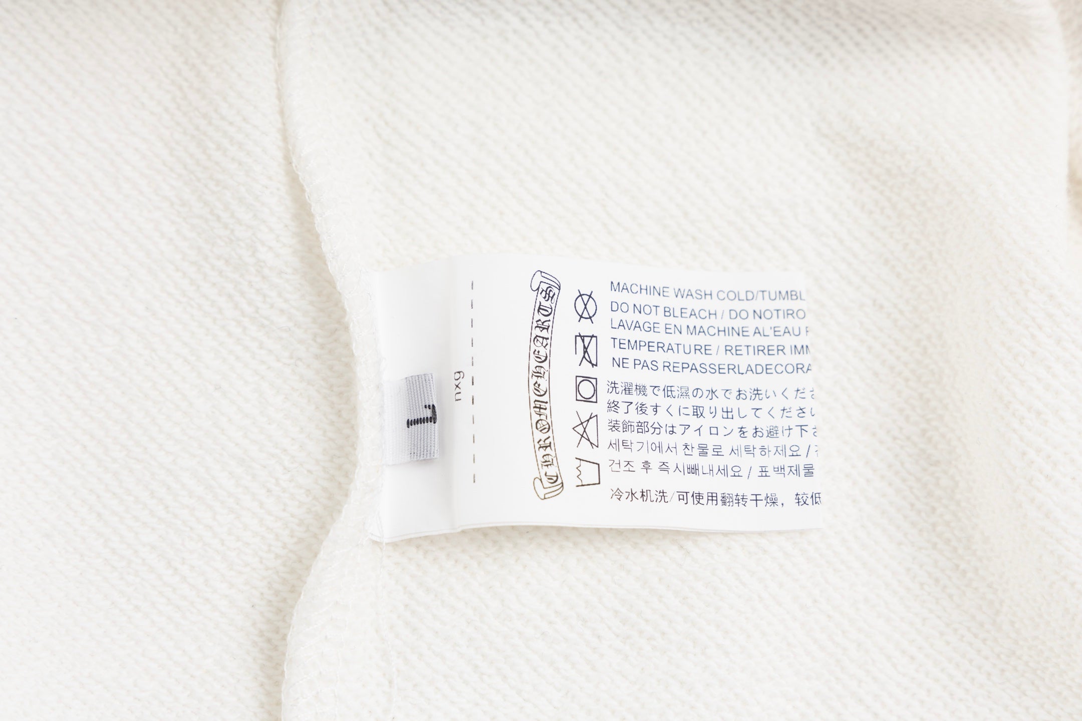 White long-sleeve garment care label on inner neck