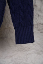 Navy knit sweater sleeve with ribbed cuff and textured cable pattern
