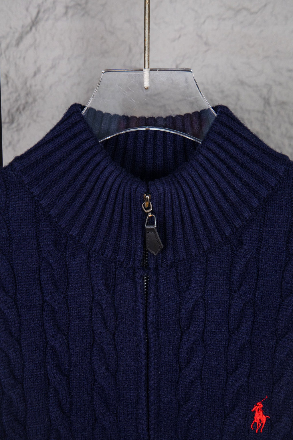 Navy knit quarter-zip sweater close-up with ribbed collar and zipper pull