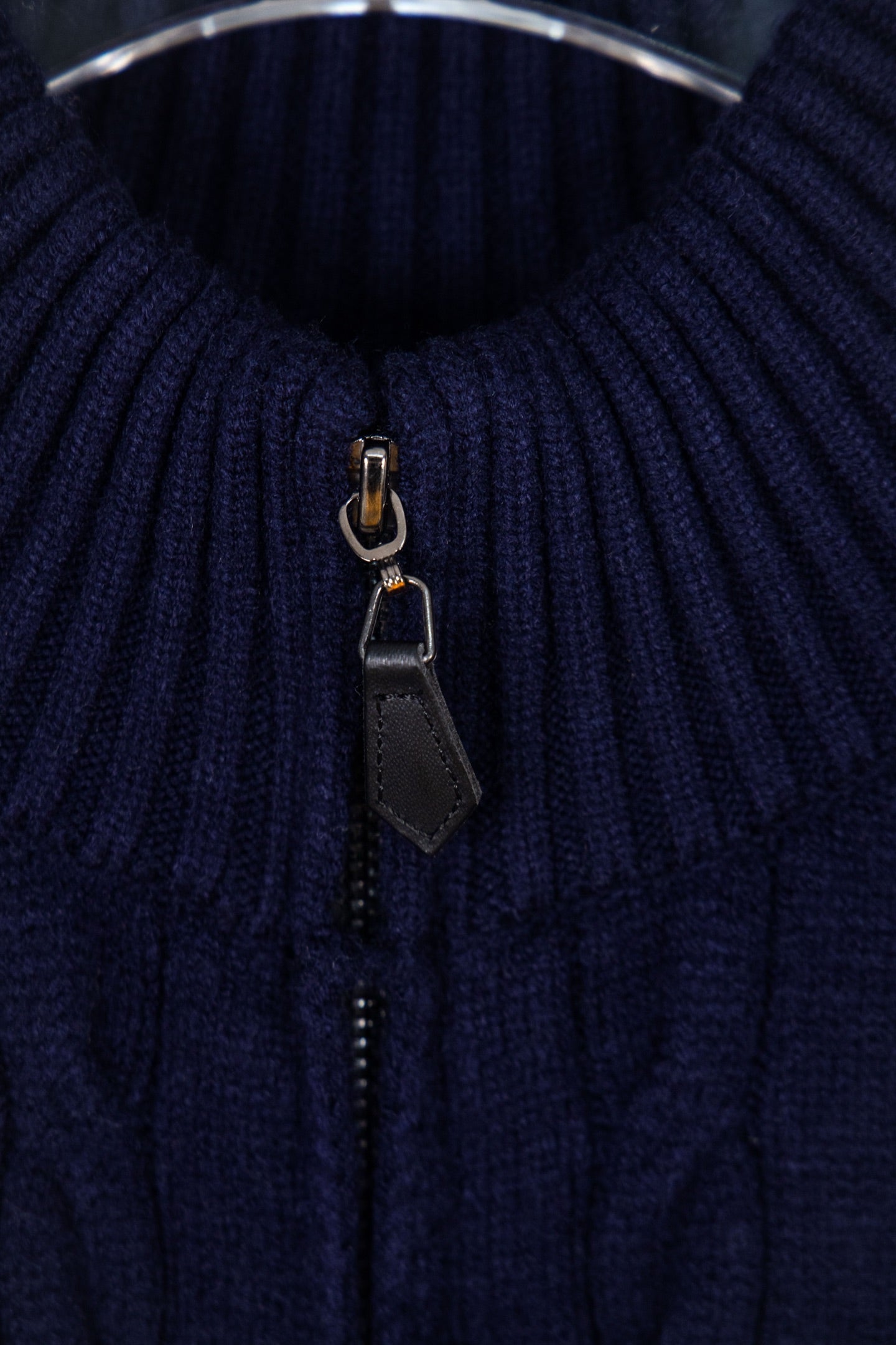 Navy knit quarter-zip sweater showing zipper pull and dark placket detail
