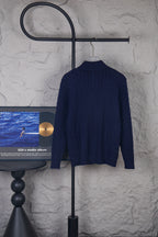 Back view of navy knit quarter-zip sweater with ribbed collar on hanger