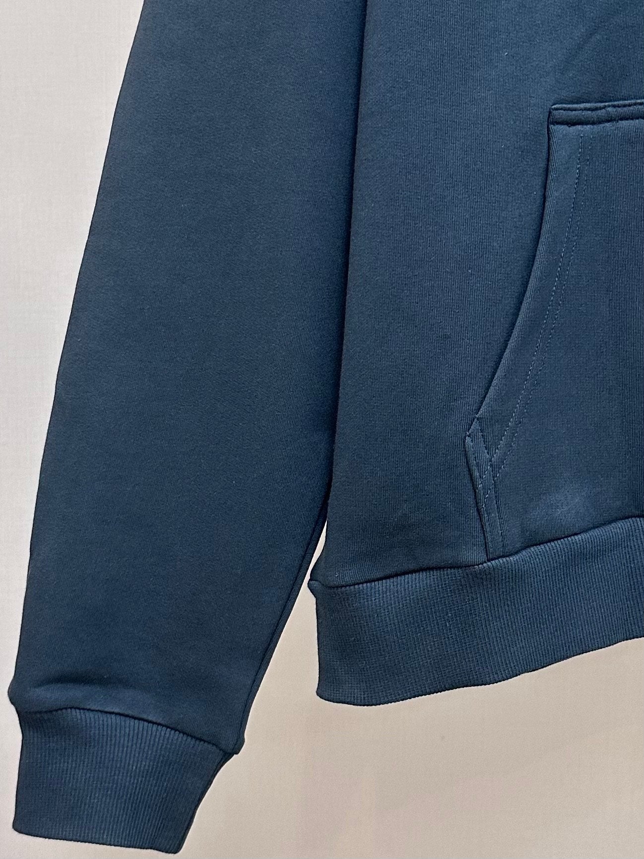Dark blue hoodie with kangaroo pocket and ribbed cuffs; partial logo print