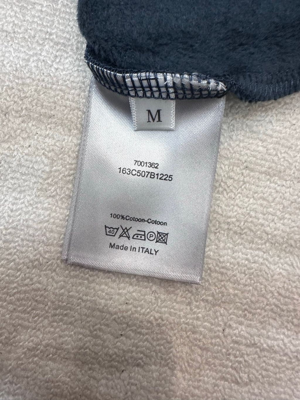 Cotton hoodie care label with size M and 'Made in Italy' text