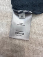 Cotton hoodie care label with size M and 'Made in Italy' text