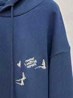 Navy hoodie with graphic text and multiple sailboat prints on chest