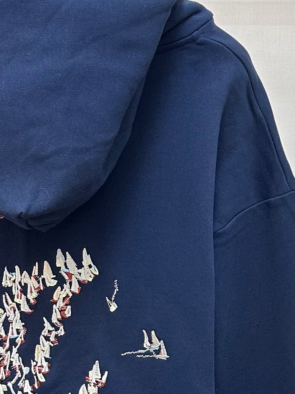 Navy hoodie side view with partial back print and sailboat details