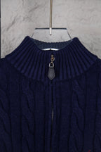 Navy cable-knit quarter-zip sweater neckline with zip pull and ribbed collar