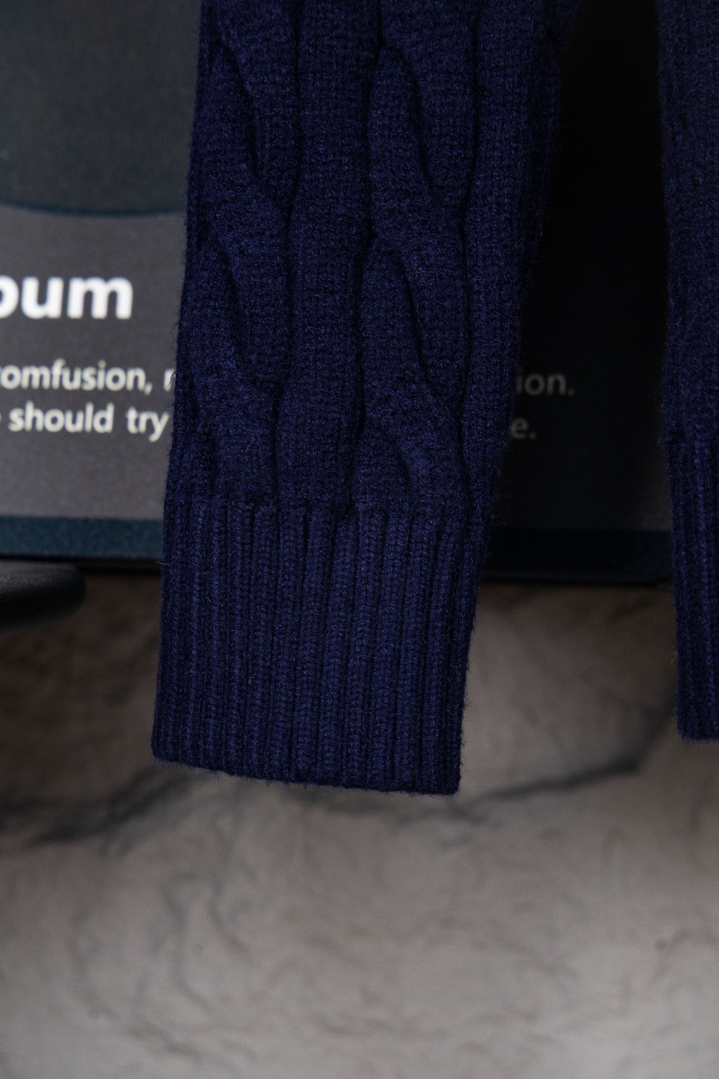 Navy cable-knit sweater sleeve with ribbed cuff