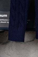 Navy cable-knit sweater sleeve with ribbed cuff