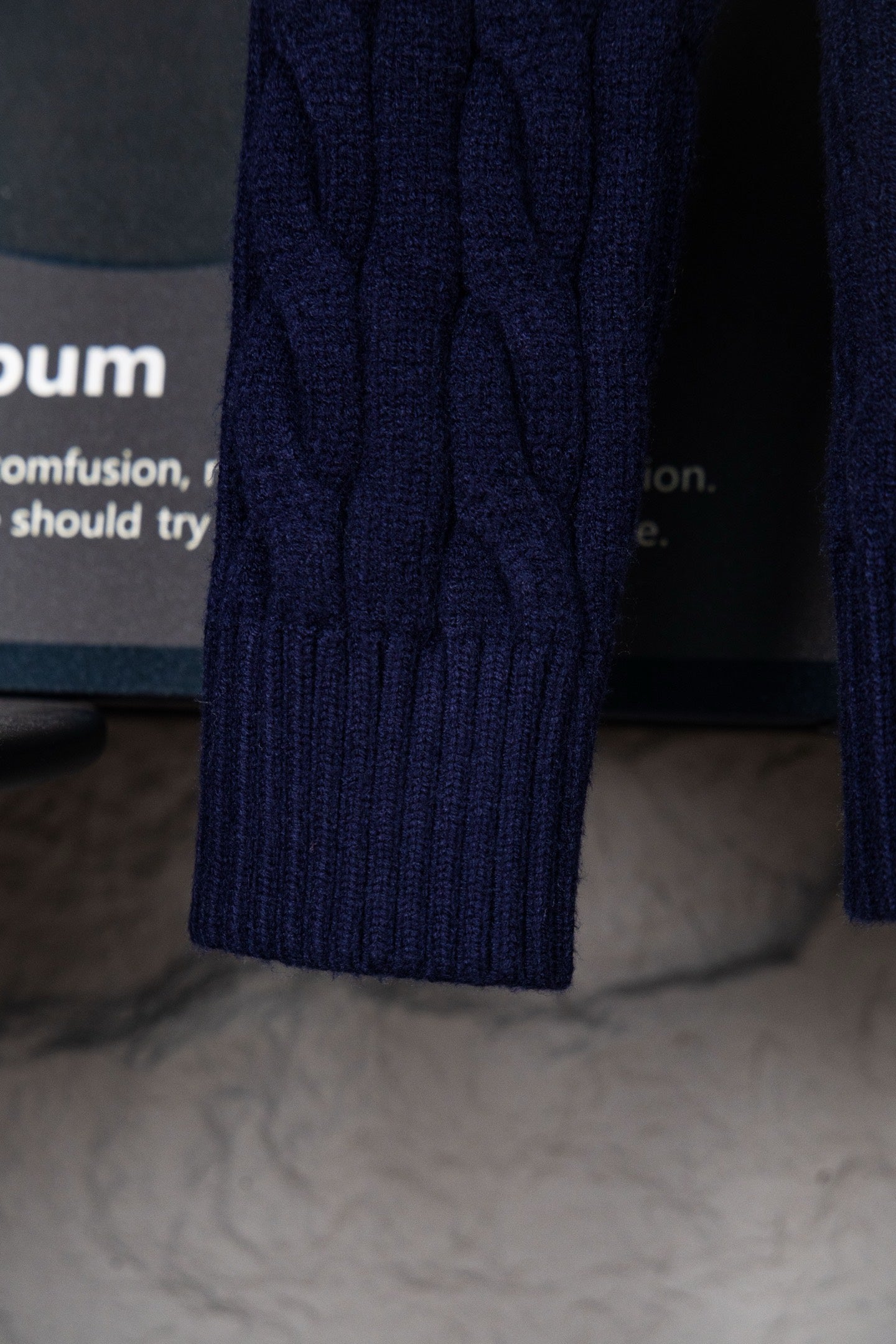 Navy cable-knit sweater sleeve with ribbed cuff