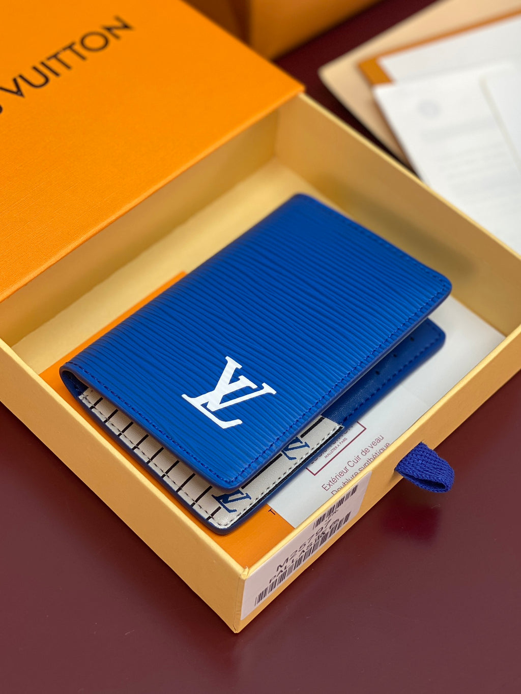 Blue Louis Vuitton small bag with front flap open and interior card slots visible