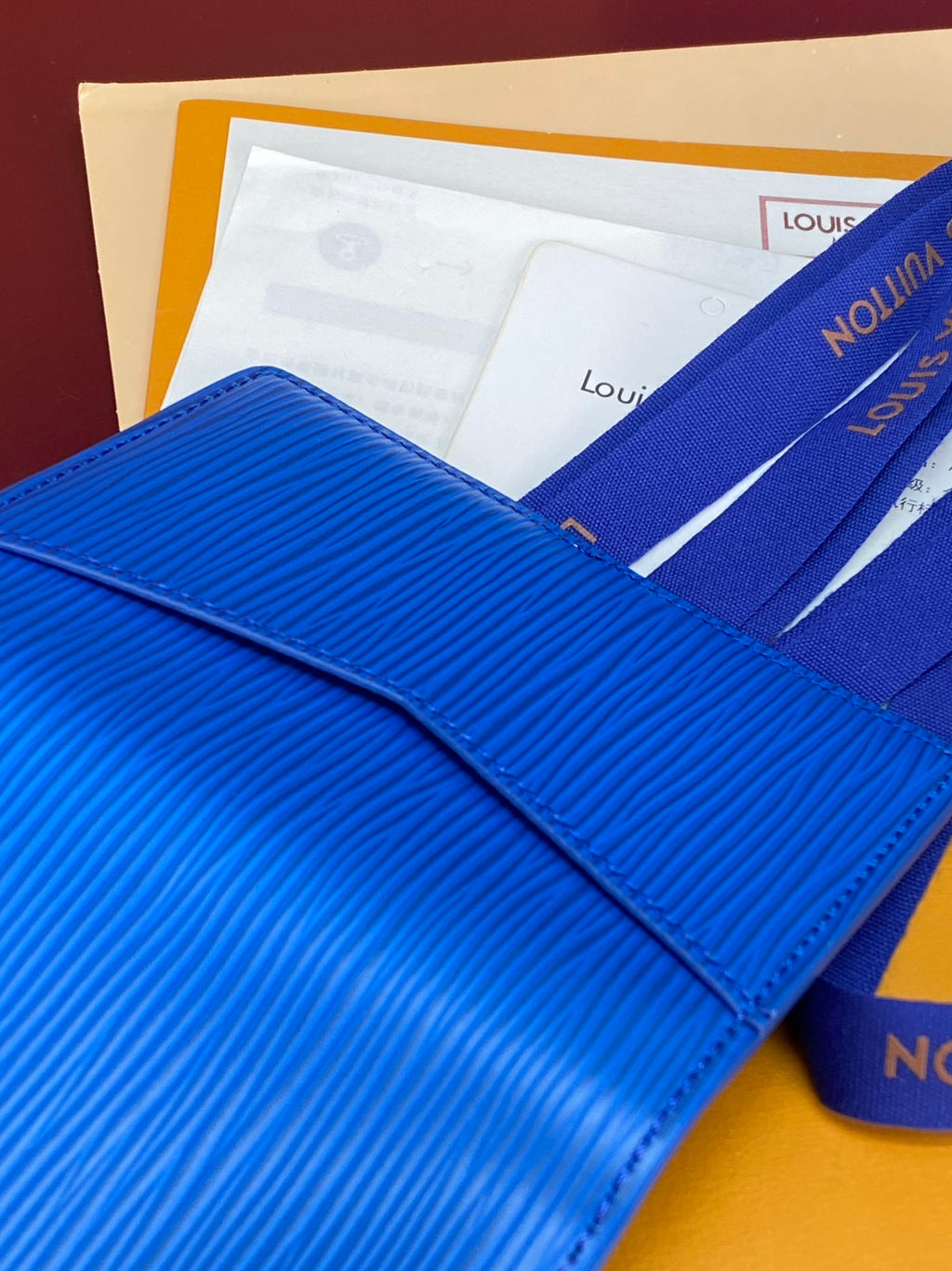 Blue Louis Vuitton small bag close-up with textured flap and stitched edge