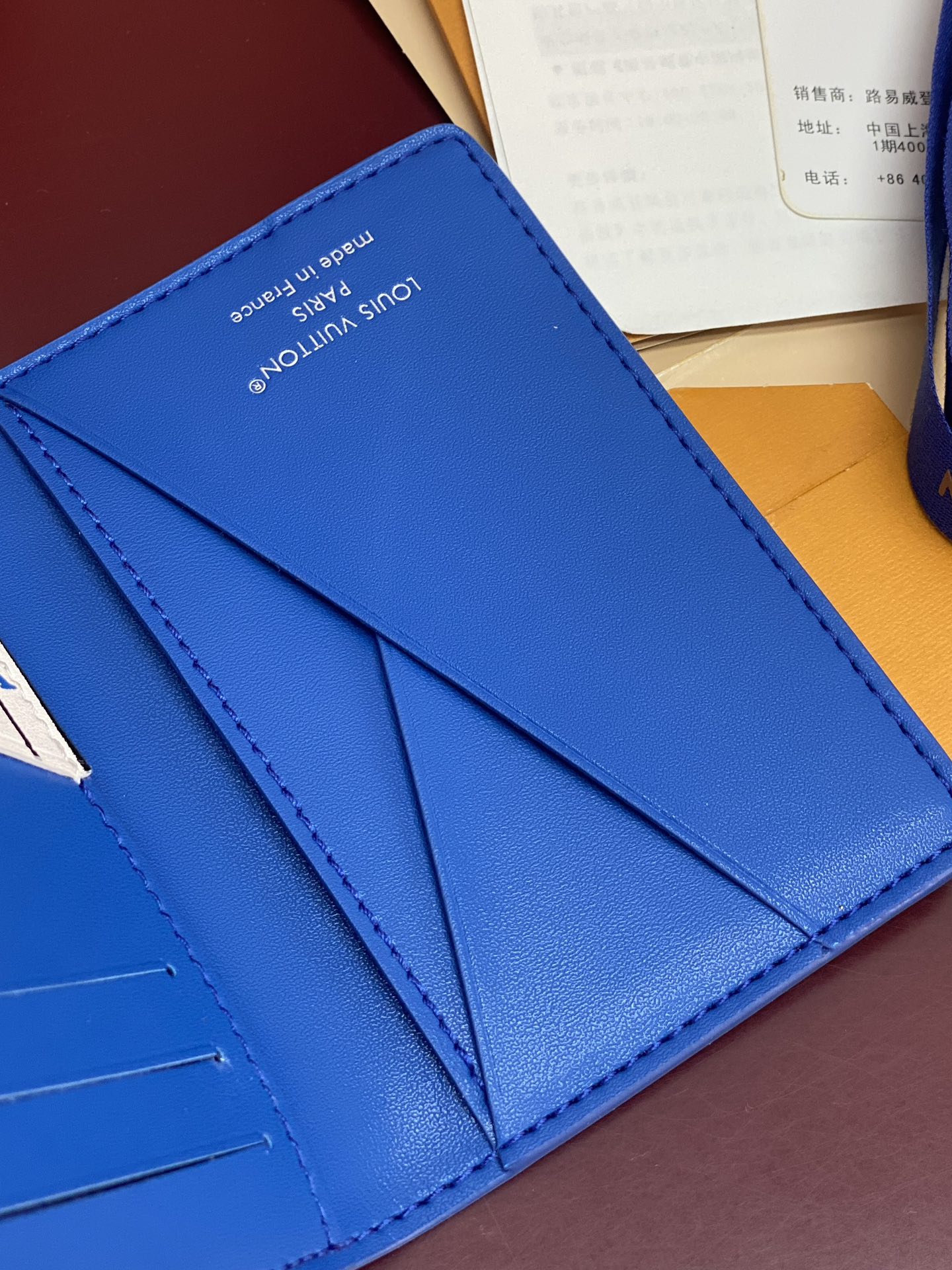 Blue Louis Vuitton small bag interior view with multiple card slots and divider