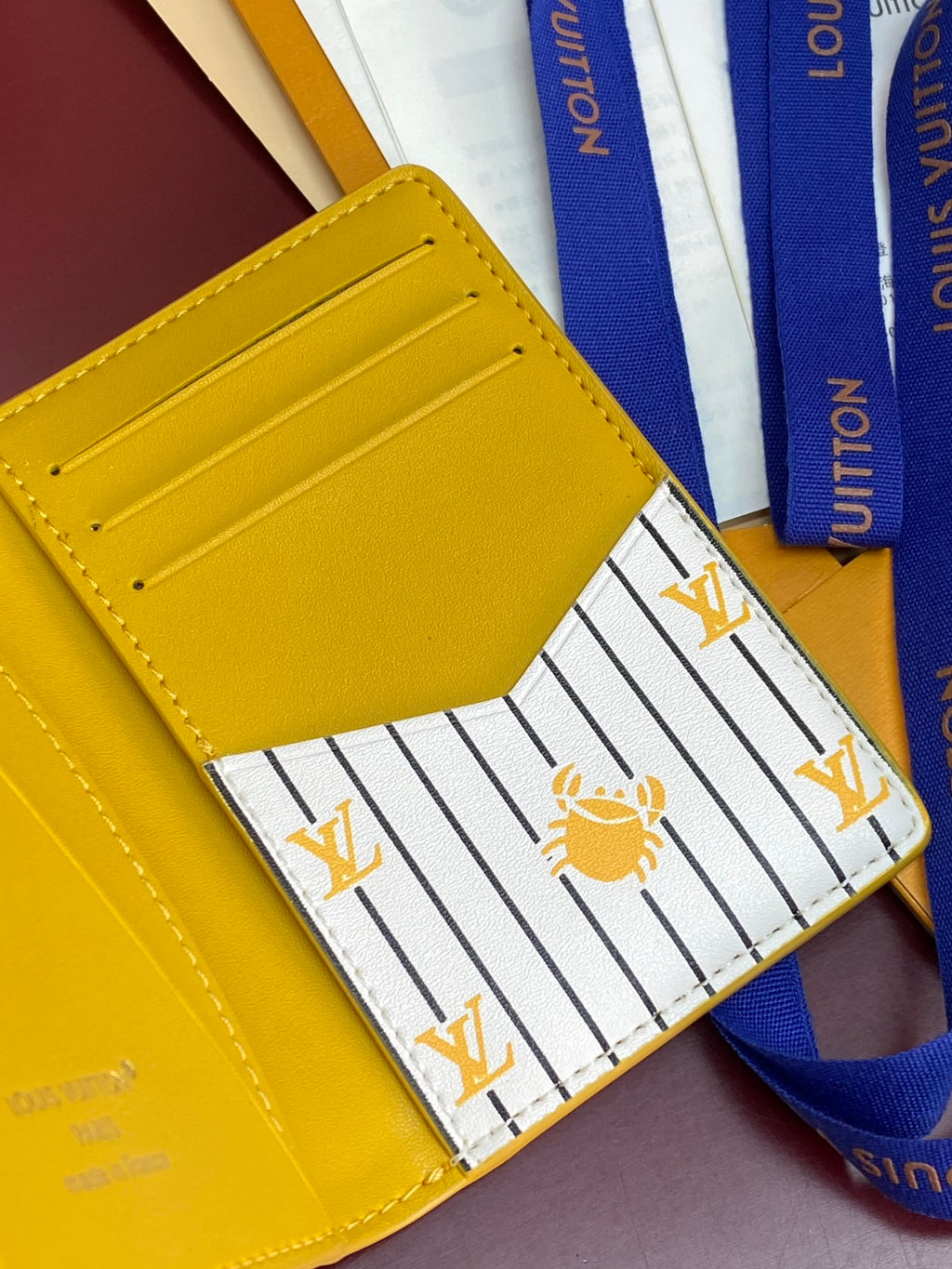 Yellow leather card holder front pocket, open with striped lining