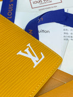 Yellow leather card holder close-up with large LV logo on textured surface