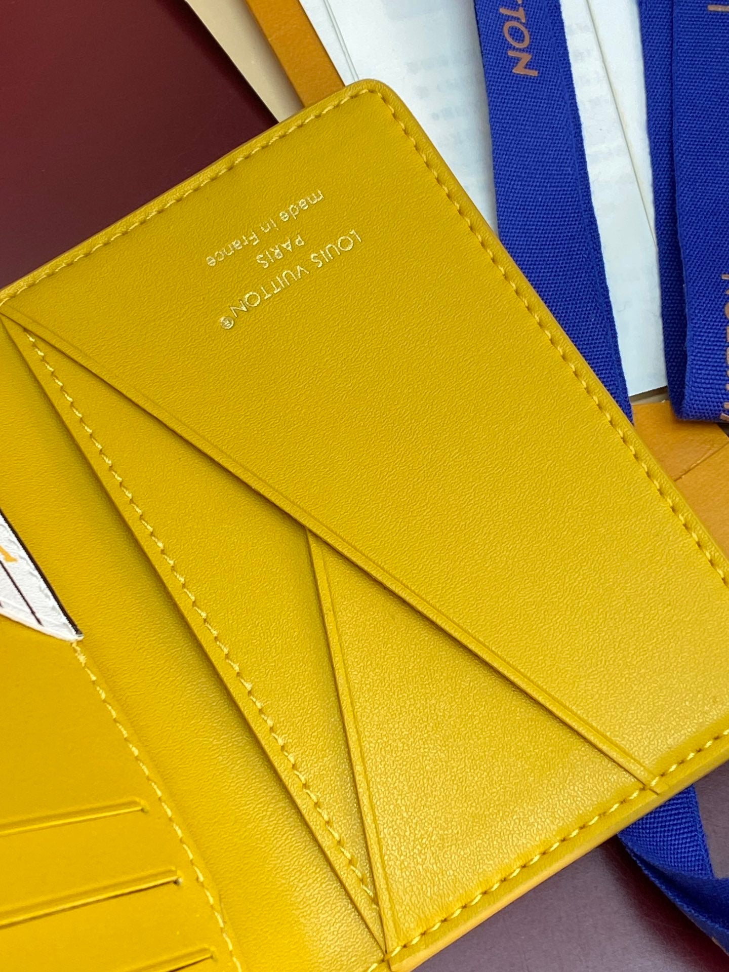 Yellow leather card holder interior with stitched card slots and fold seam