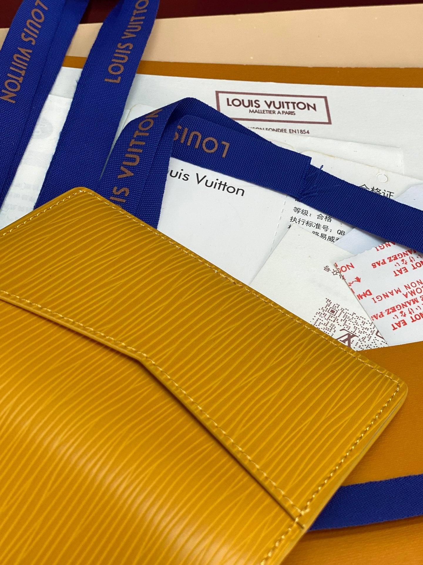 Yellow textured leather card holder with exterior LV logo and blue strap