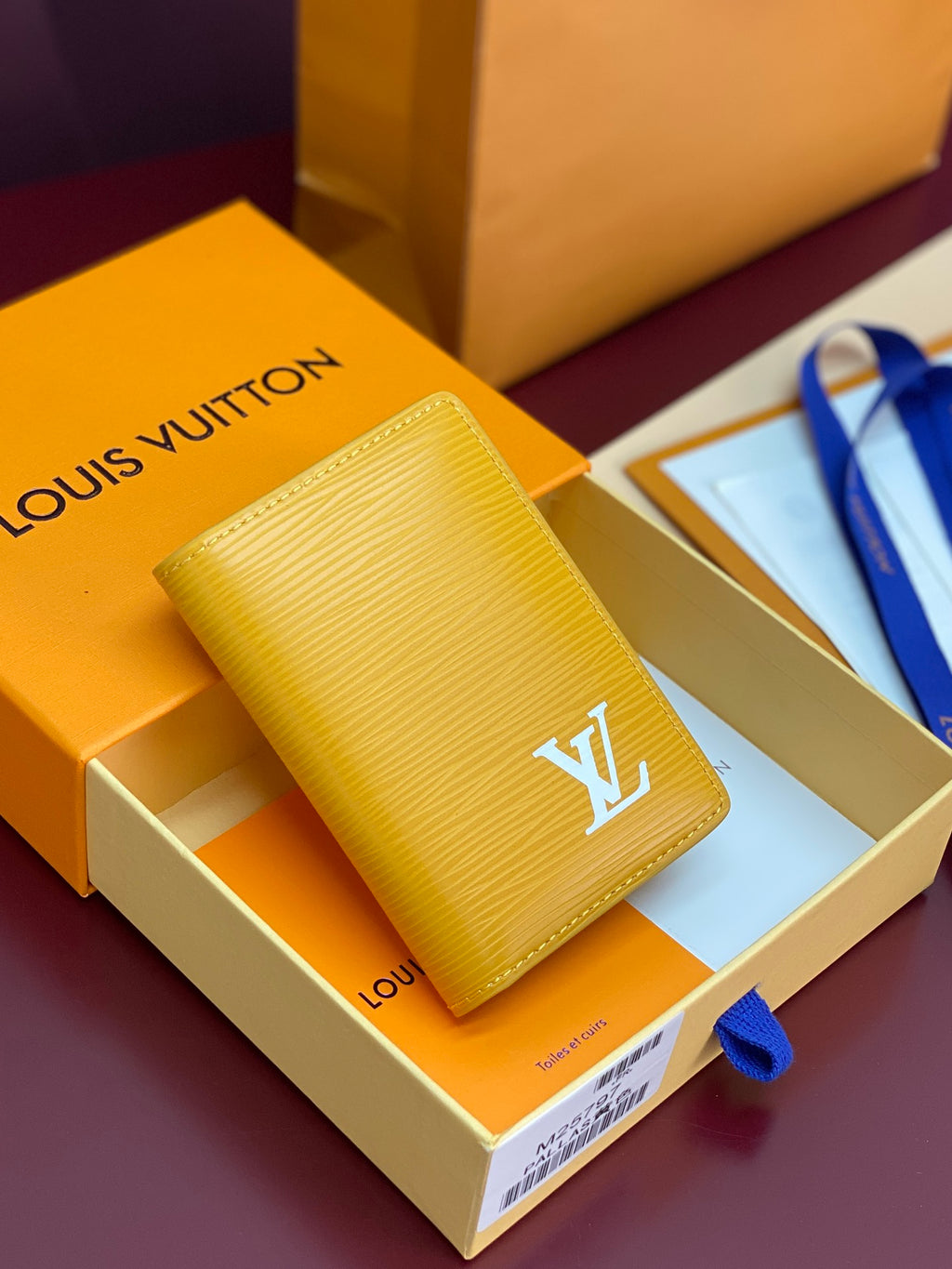 Yellow textured leather card holder with gold LV logo on front