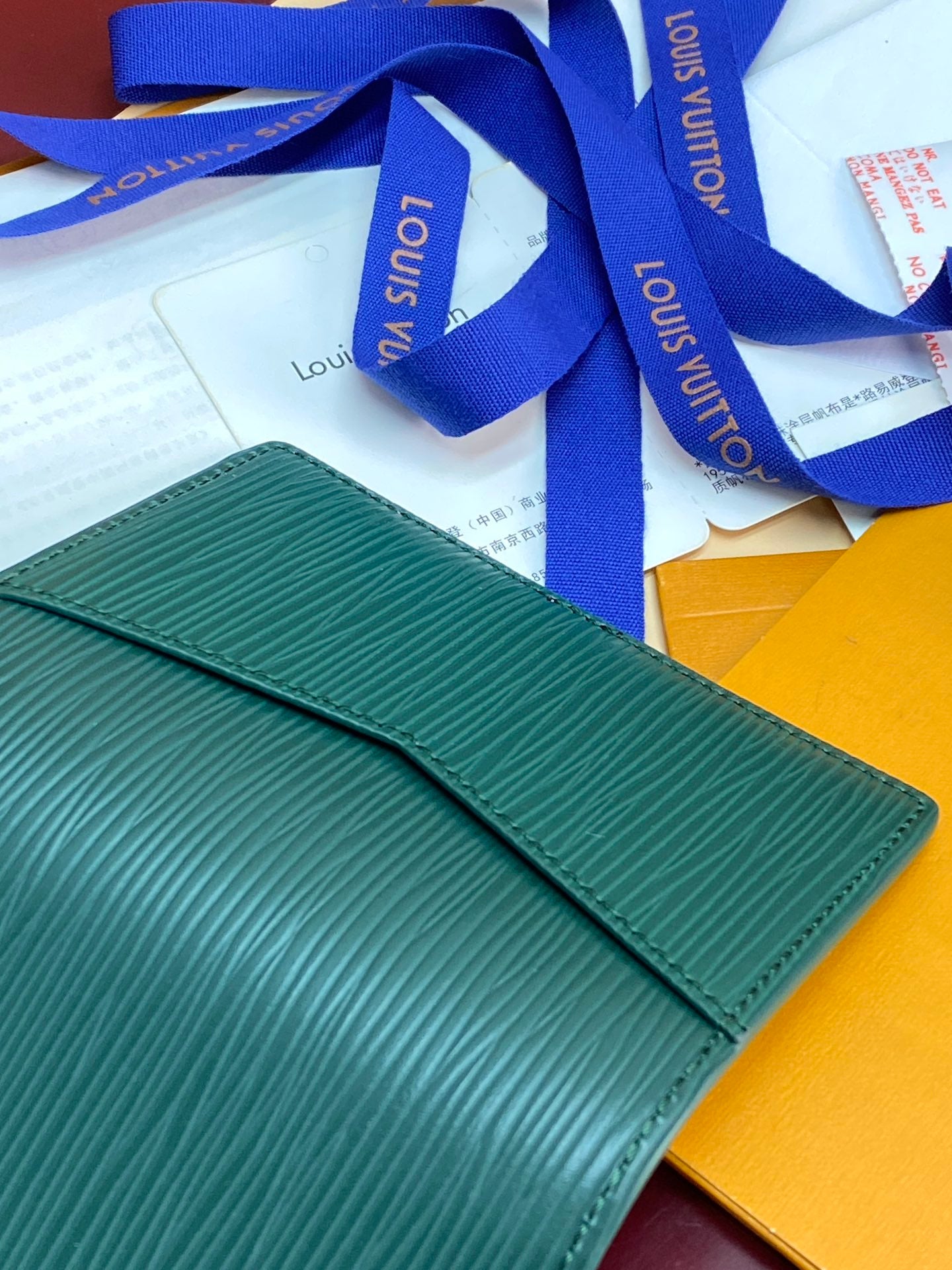 Louis Vuitton small bag wallet, teal green exterior with blue ribbon on packaging