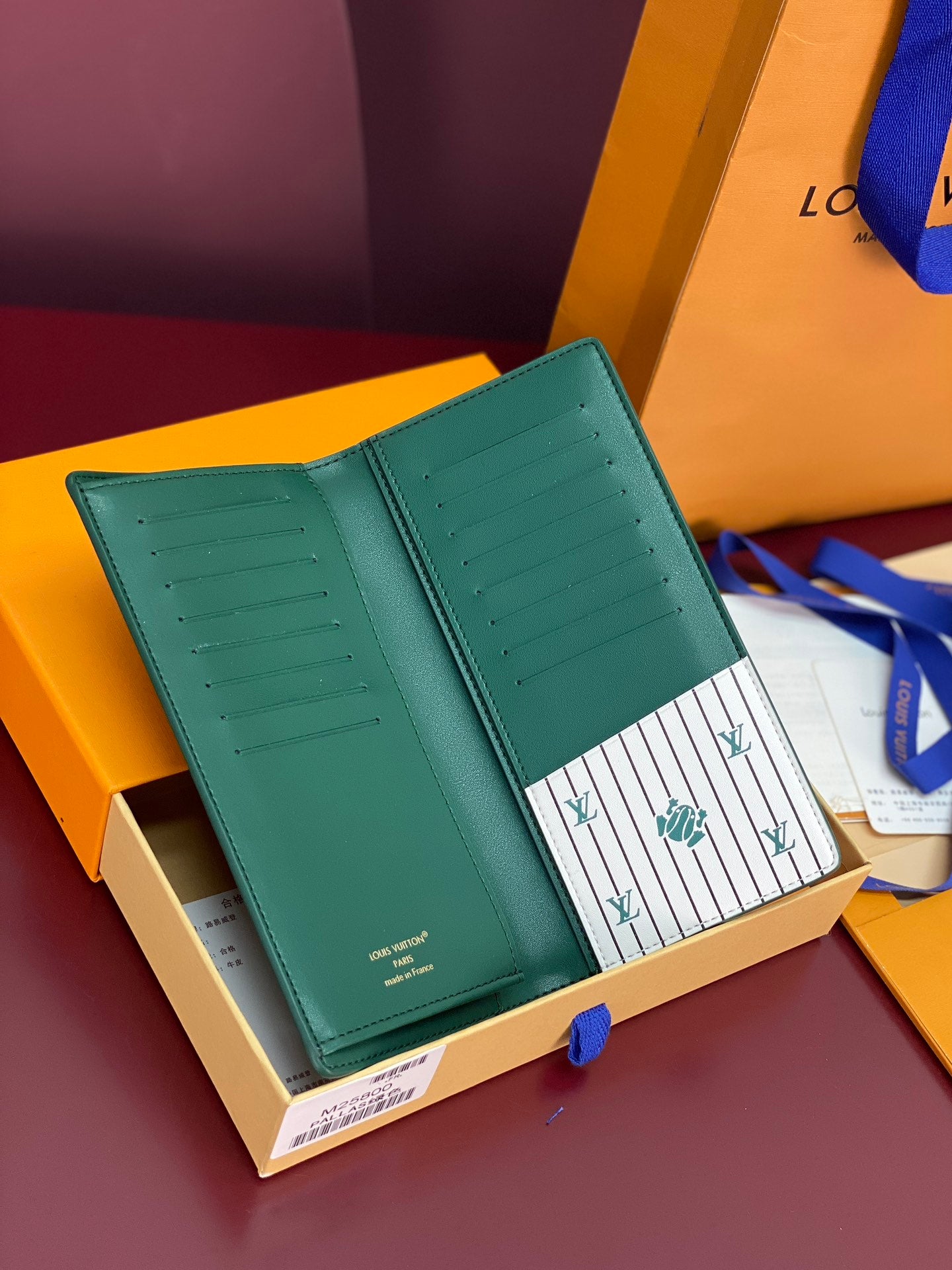 Louis Vuitton green long wallet opened flat, showing interior card slots