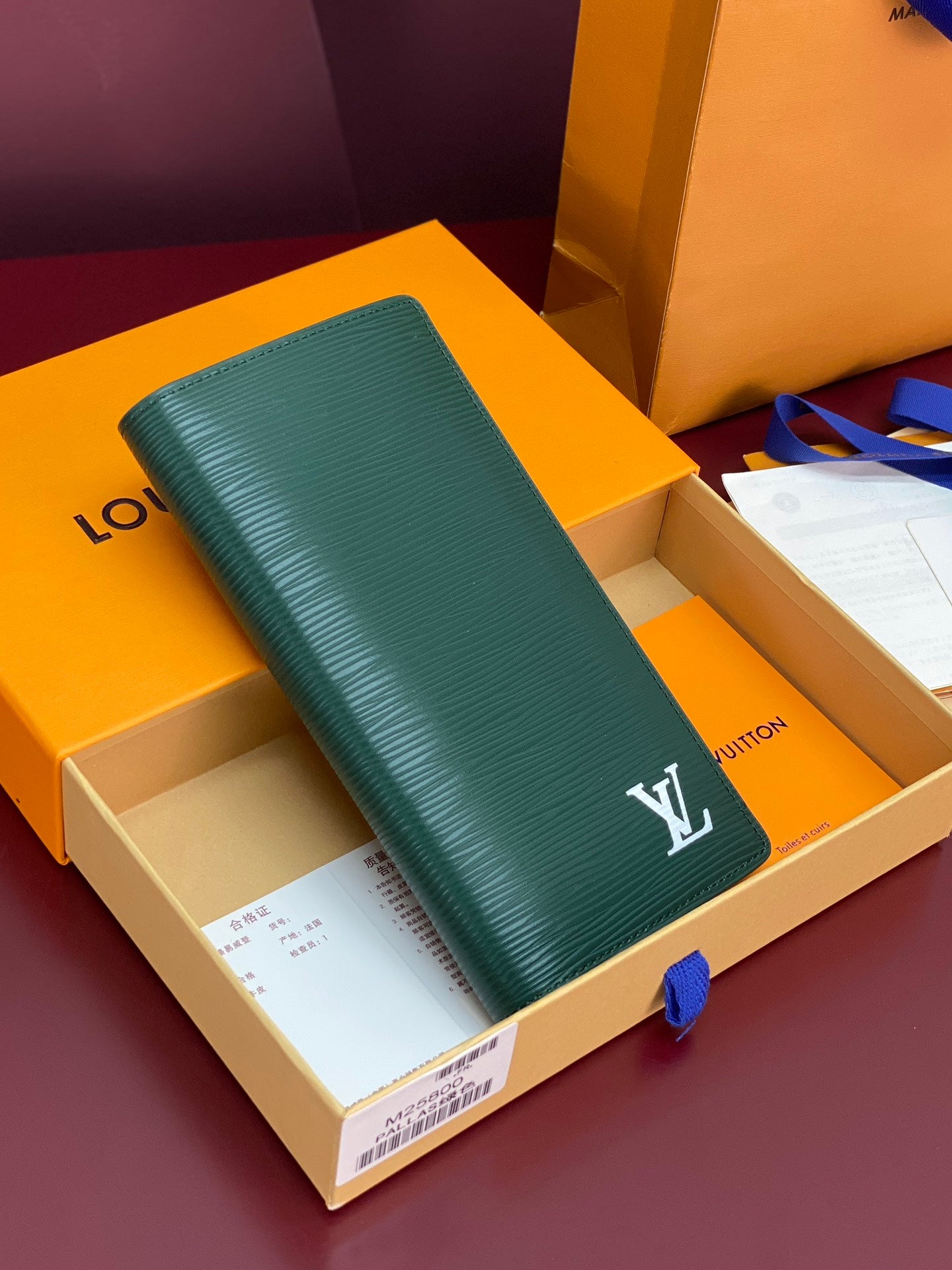 Teal small wallet with embossed texture and white LV logo on the front flap