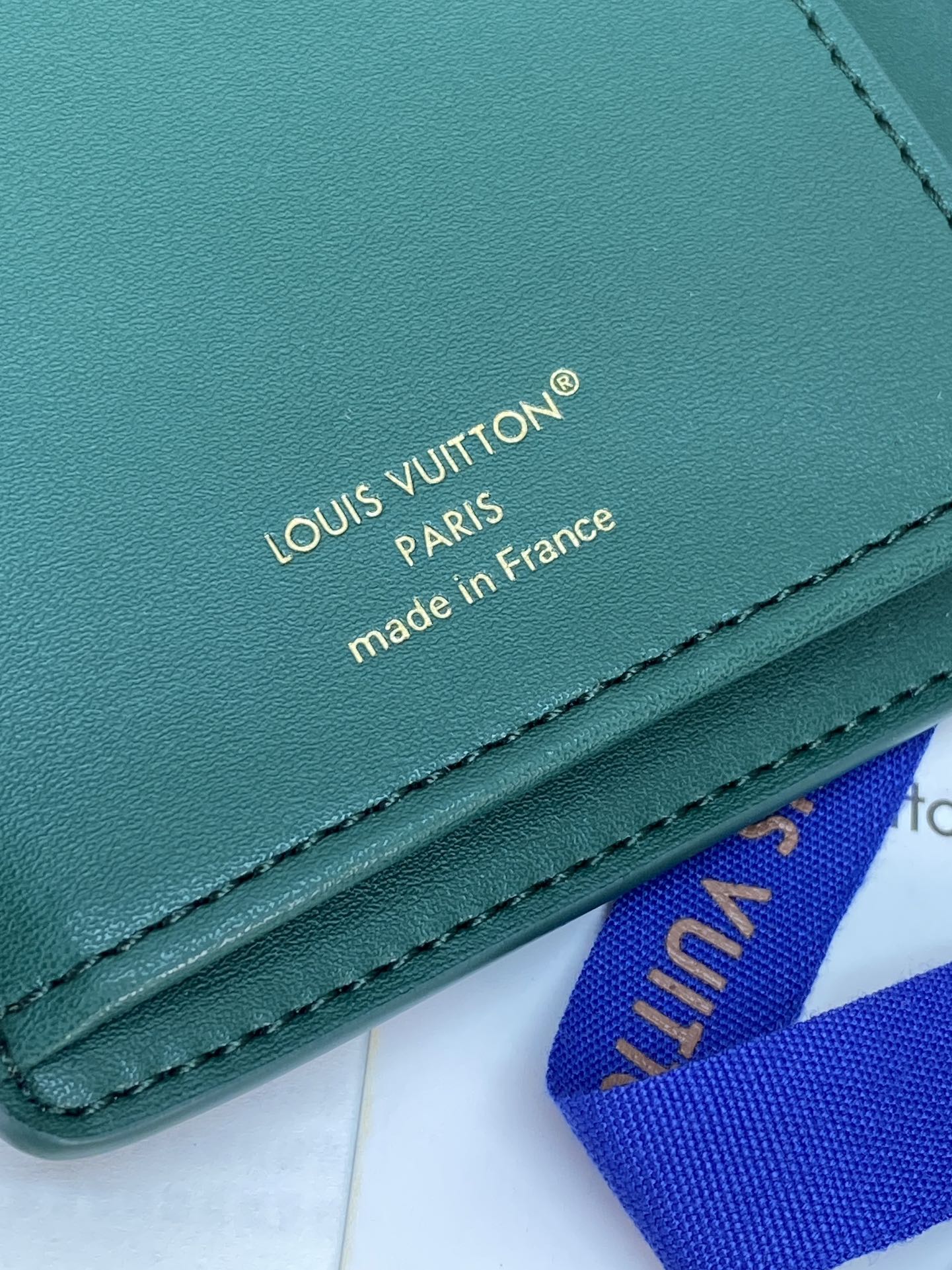 Teal leather wallet with embossed Louis Vuitton Paris and made in France text