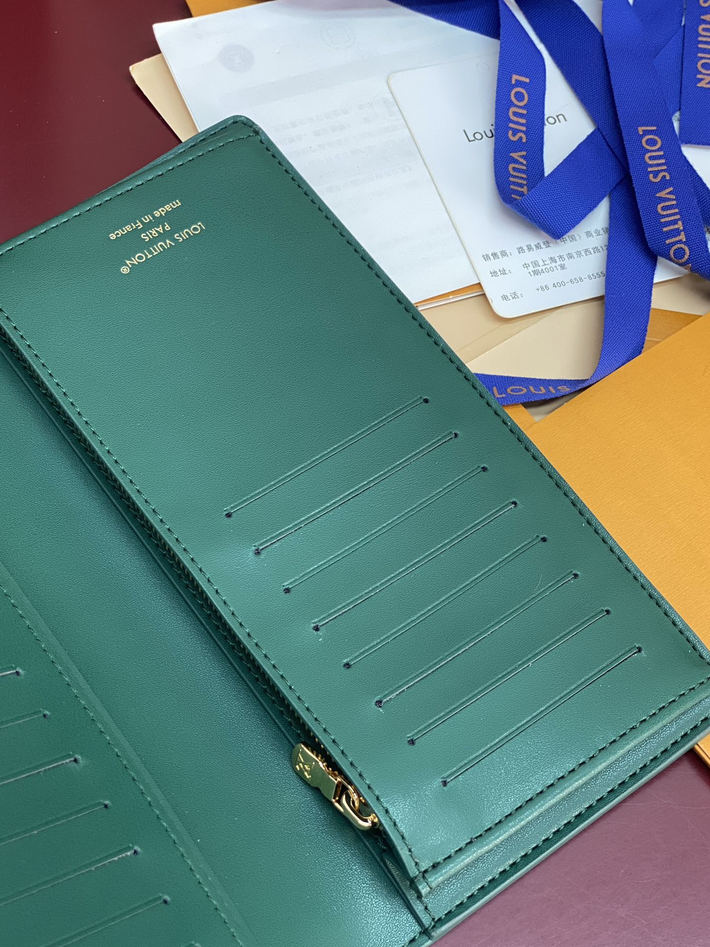 Teal small wallet with card slots and gold-tone zipper hardware on the front