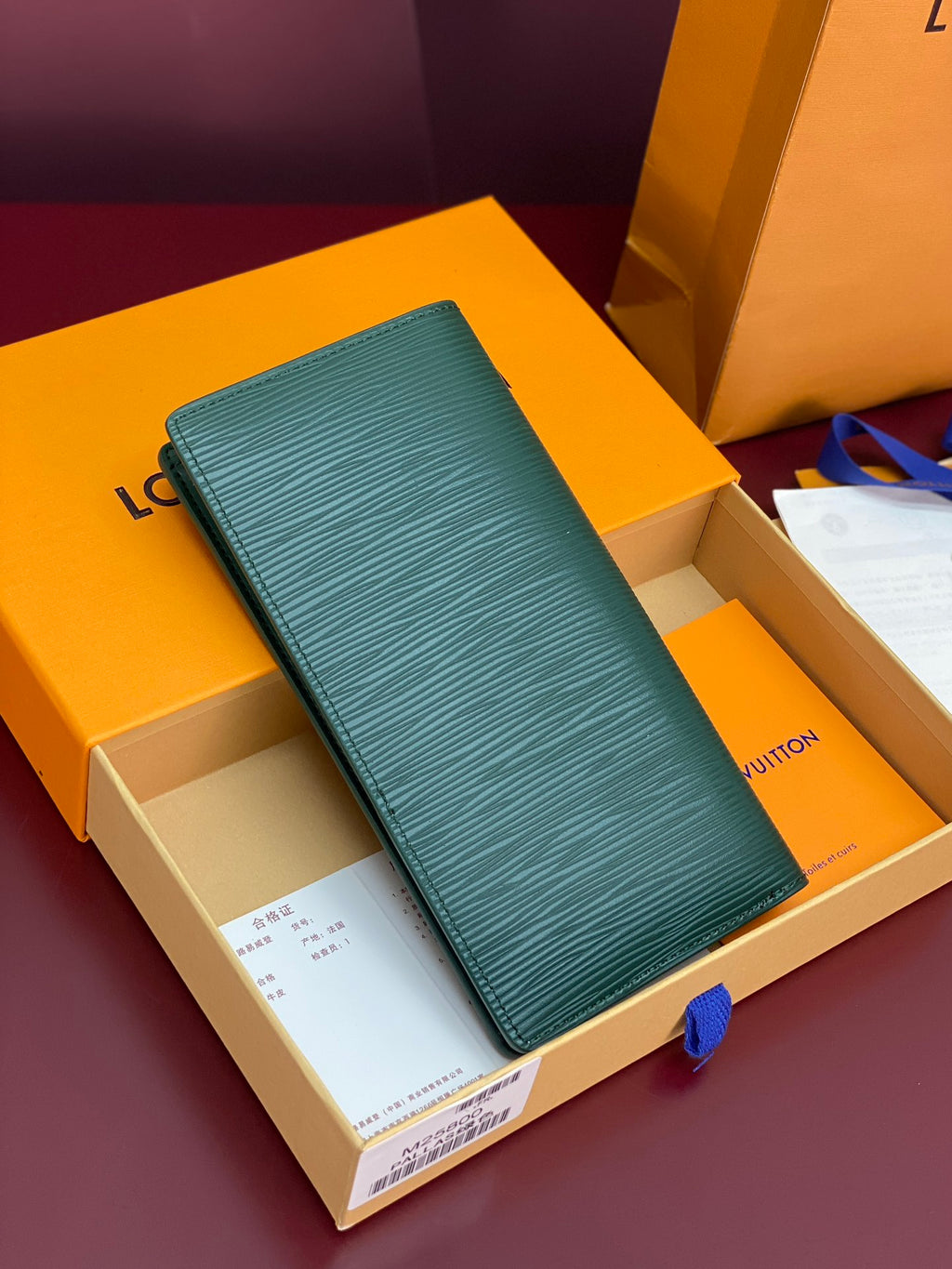 Teal small wallet with embossed texture and white LV logo, shown on the front