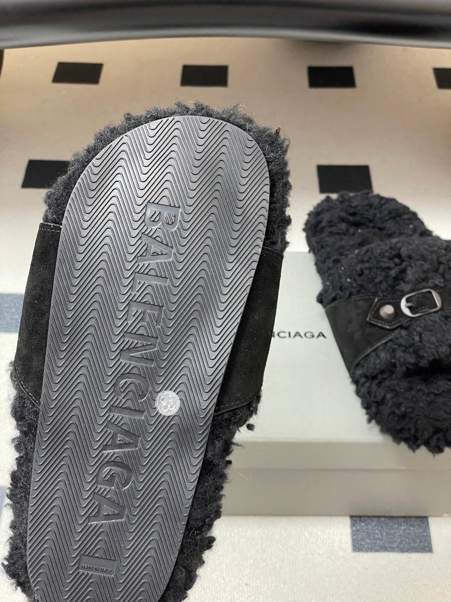 Black Balenciaga sandals shown from sole, textured rubber tread