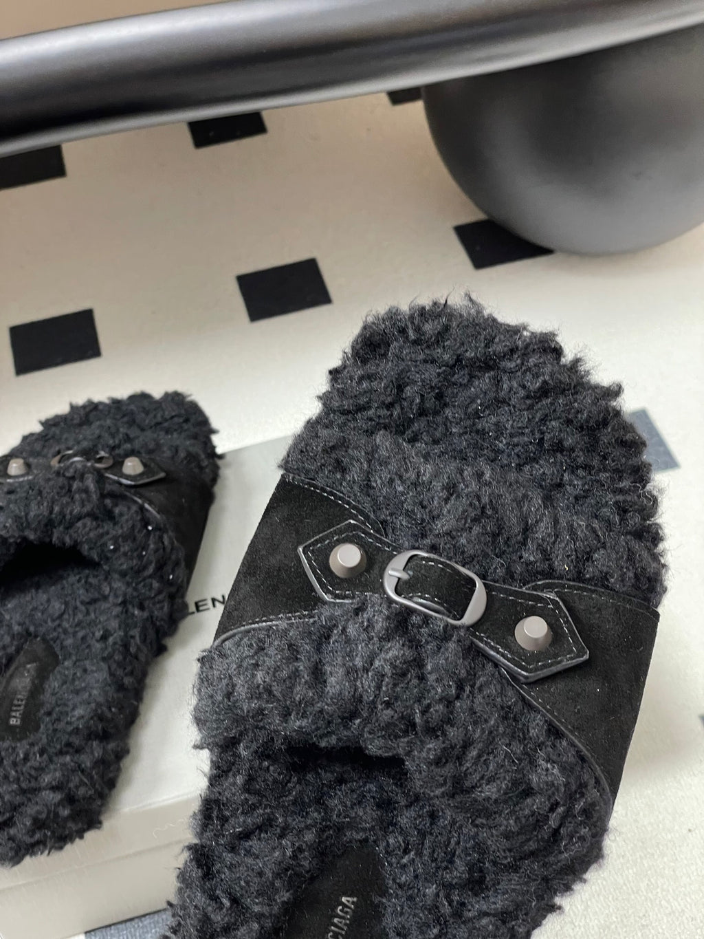 Black Balenciaga sandals with front strap and oval metal buckle, close-up
