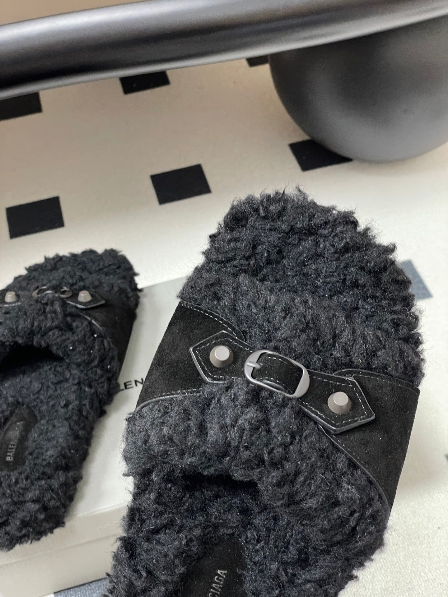 Black Balenciaga sandals with front strap and oval metal buckle, close-up