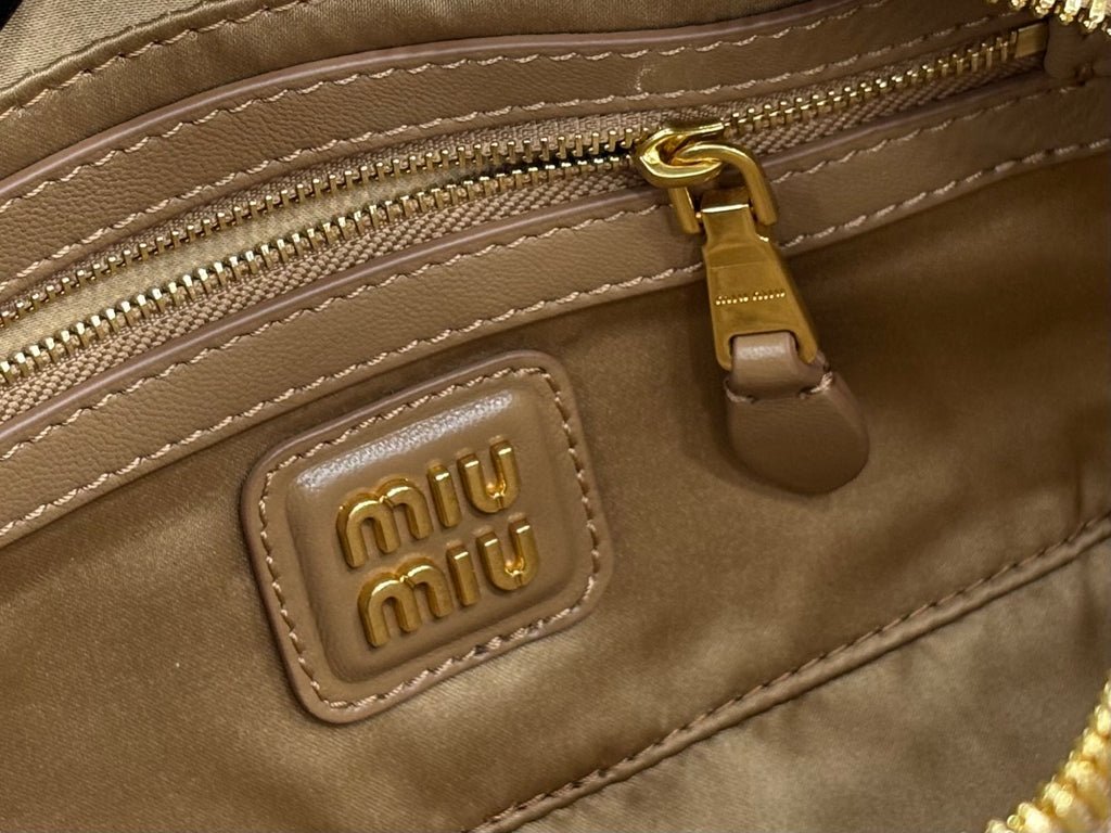 Taupe leather interior pocket with gold zipper and Miu Miu logo patch
