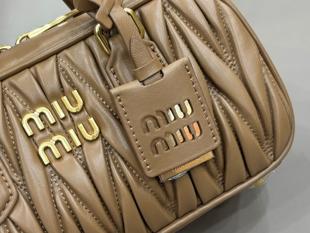 Taupe quilted leather bag detail with two front Miu Miu logo plaques and stitching
