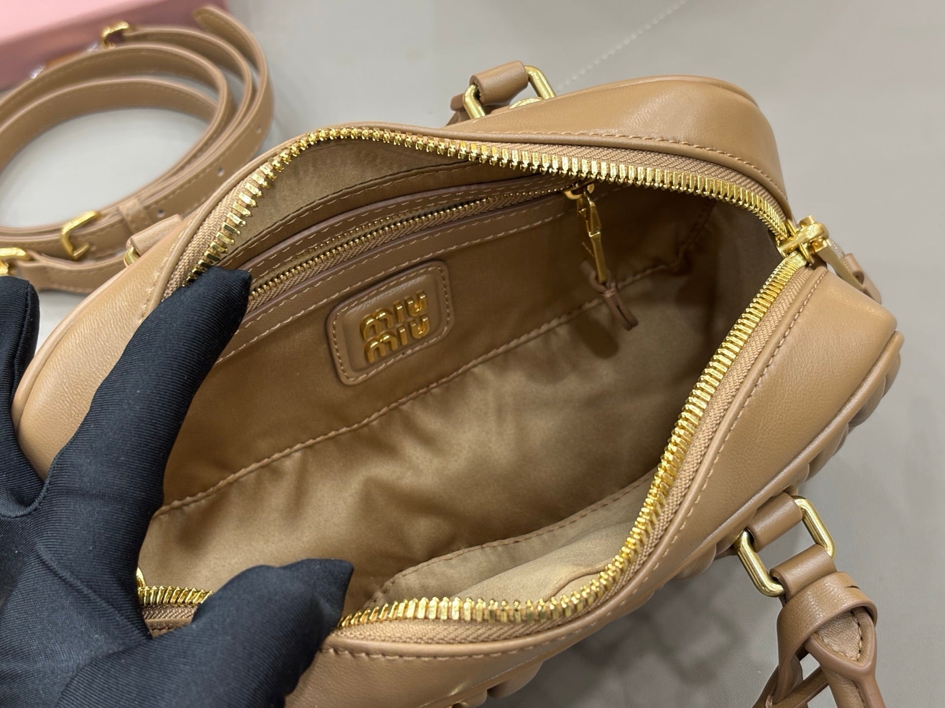 Taupe leather mini bag interior with zip pocket and beige lining