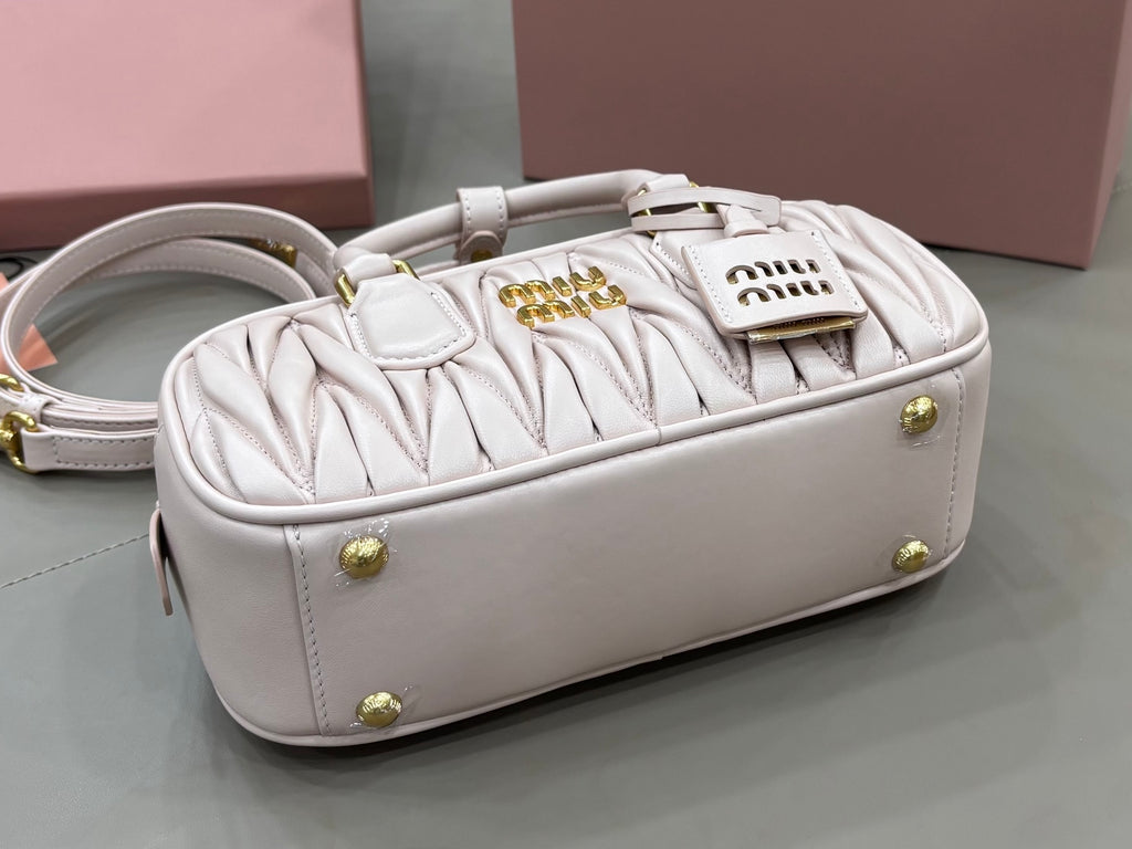 MiuMiu light gray mini bag with top handles, gold studs, and side view