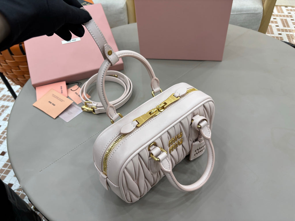 MiuMiu light gray mini satchel with two handles, quilted sides, and gold hardware