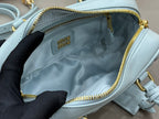 MiuMiu light blue mini bag interior view with gold-tone zipper and logo patch