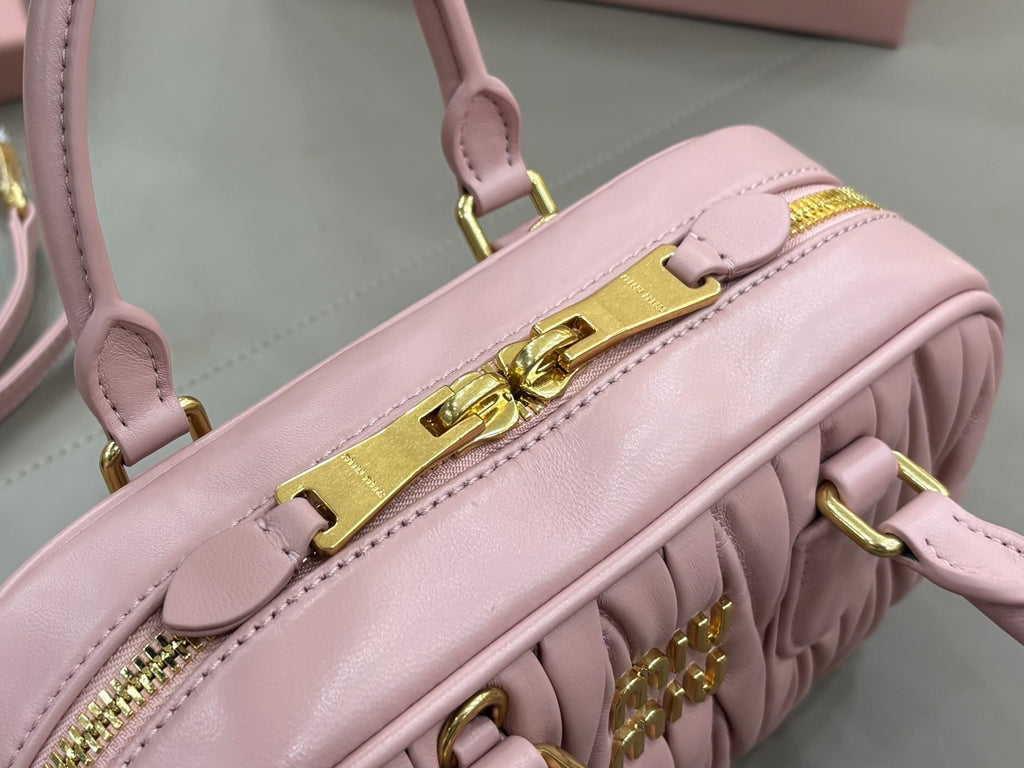 Miu Miu light pink bag with gold-tone top handle hardware and zipper pull