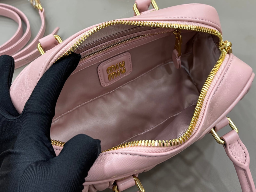 Miu Miu light pink mini bag with open top, brown lining, and gold zipper