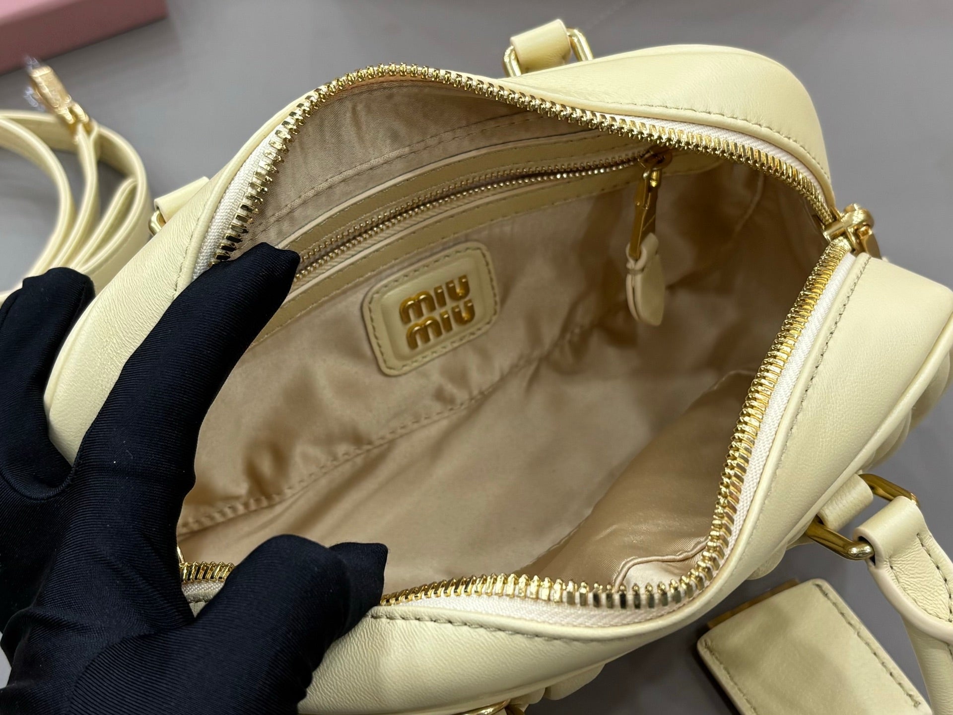 Light yellow Miu Miu bag interior view with fabric lining and zipper opening