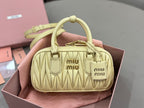 Light yellow quilted leather Miu Miu bag with top handle and gold-tone hardware